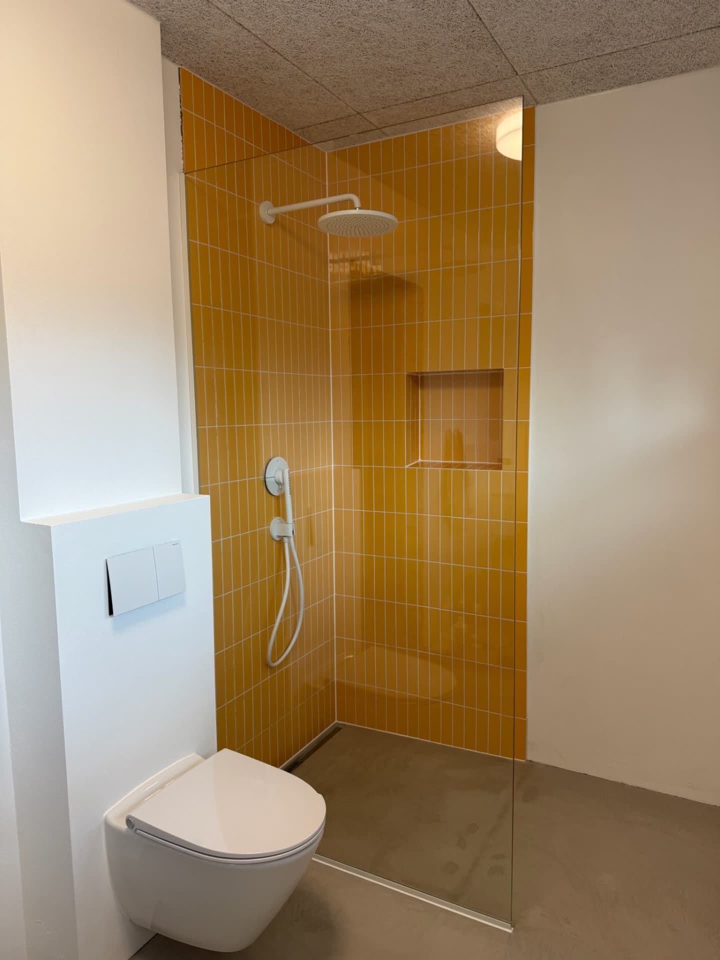 Bruseniche med karrygule fliser og rammeløst glas