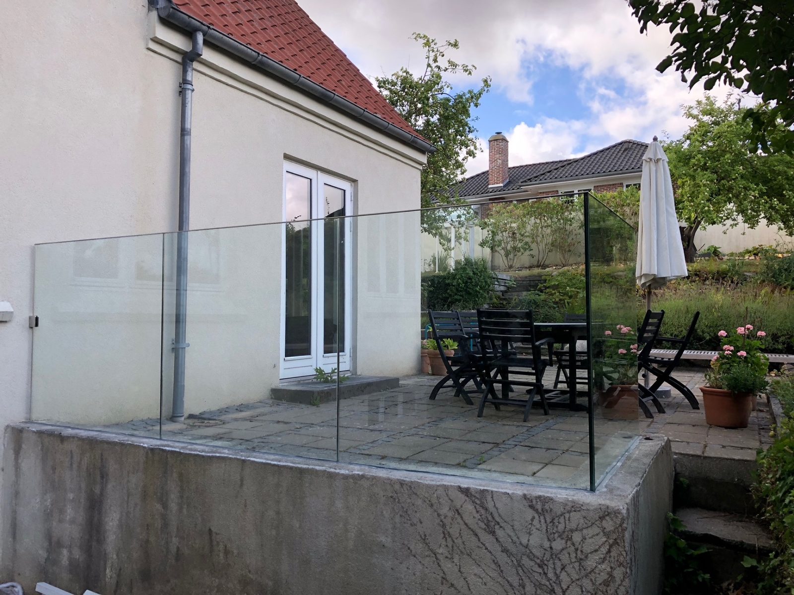 Glasværn i klart glas omkring havehave-terrasse